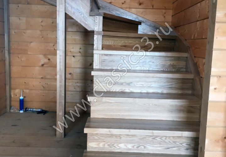 Лестница с забежными ступенями из ясеня с кованной балюстрадой